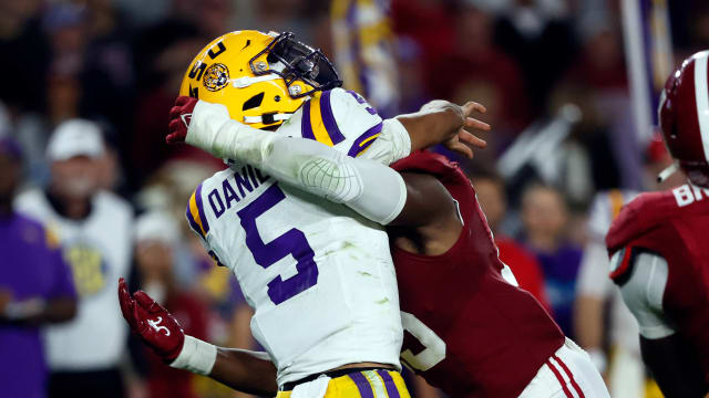 Nov 4, 2023; Tuscaloosa, Alabama, USA; LSU Tigers quarterback Jayden Daniels (5) is hit by Alabama Crimson Tide linebacker Dallas Turner (15) as he throws the ball during the second half at Bryant-Denny Stadium.